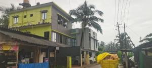 Un edificio amarillo con una palmera delante. en Moonstar guesthouse, en Māvalli