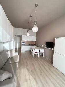 a kitchen and living room with a table and chairs at Rucola Home in Castione della Presolana