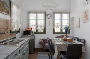 a kitchen with a table with chairs and a sink at Εν Καρδιά in Ioannina