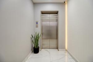 a hallway with a door and a potted plant at Hotel Sukoon & Banquet Hall Near Bhopal Railway Station in Bhopal