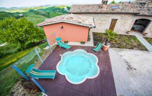 an aerial view of a pool with chairs and a house at 2 Bedroom Nice Apartment In Sant'angelo In Vado in Piandimeleto