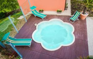 a group of chairs sitting around a table and a pool at 2 Bedroom Nice Apartment In Sant'angelo In Vado in Piandimeleto