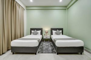 two twin beds in a room with curtains at Hotel Sukoon & Banquet Hall Near Bhopal Railway Station in Bhopal +20 photos