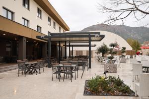 a patio with tables and chairs and a building at Hotel Karting in Mostar
