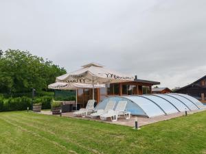 une grande maison en forme de dôme bleu avec des chaises et des parasols dans l'établissement Kuća za odmor Krolo - Blackberry Hill, à Kupinovac