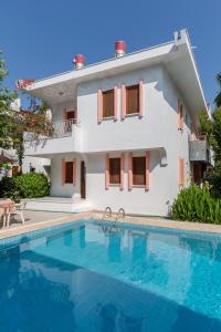 a villa with a swimming pool in front of a house at Flower Villa Apart in Kemer +26 photos