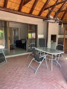 a table and chairs on a patio with a couch at Ubuntu Guest House in Cape Town