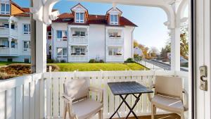 a balcony with a table and chairs and a house at Appartementhaus Binzer Sterne 23 in Binz