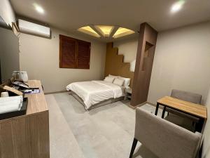 a bedroom with a bed and a desk and a table at 계룡 호텔 스테이318 in Gyeryong