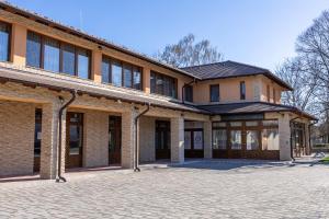 Un antiguo edificio de ladrillo con una entrada enfrente. en Vörös Álom Apartman Panzió, en Tiszakécske