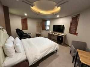 a bedroom with a bed and a desk and a television at 계룡 호텔 스테이318 in Gyeryong +54 photos