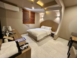 a hotel room with a bed and a desk and a desk at 계룡 호텔 스테이318 in Gyeryong