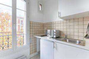 a kitchen with a sink and a window at Cosy Studio Asnieres in Les Grésillons +5 photos