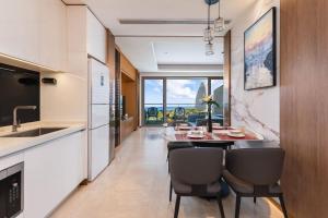 a kitchen and dining room with a table and chairs at 来咖民宿酒店三亚海棠湾亚特兰蒂斯棠岸店 in Fengtang