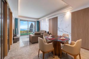 a living room with a table and chairs and a couch at 来咖民宿酒店三亚海棠湾亚特兰蒂斯棠岸店 in Fengtang