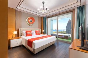 a bedroom with a bed with a view of the ocean at 来咖民宿酒店三亚海棠湾亚特兰蒂斯棠岸店 in Fengtang