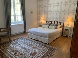 a bedroom with a bed with two lamps and a rug at Château Sainte BARBE in Loriol-du-Comtat +31 photos