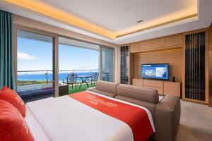 a bedroom with a large bed and a television at 来咖民宿酒店三亚海棠湾亚特兰蒂斯棠岸店 in Fengtang