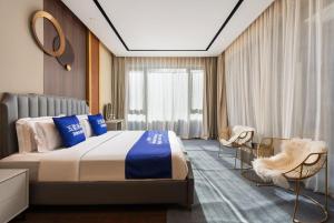 a bedroom with a large bed and two chairs at 来咖民宿酒店三亚海棠湾亚特兰蒂斯棠岸店 in Fengtang +21 photos