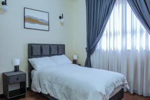 Un dormitorio con una cama y una ventana grande. en DAT Luxury Apartments, en Dirē Kʼalu