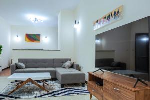 Una sala de estar con un sofá y un televisor. en DAT Luxury Apartments, en Dirē Kʼalu