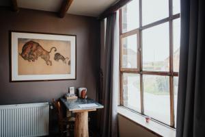 a room with a table next to a window at Buteo chambres d'hôtes & espresso in Lesterny