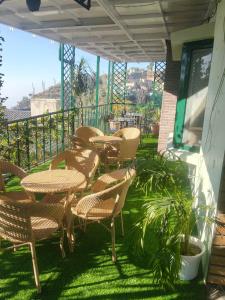 a patio with tables and chairs on a balcony at Kasauli Residency in Kasauli