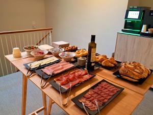 巴塞罗那Líbere Barcelona Sant Antoni的一张桌子,上面放着一大堆食物和一瓶葡萄酒