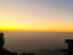 a view of the sunset from the top of a mountain at Kasauli Residency in Kasauli