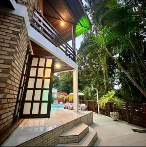 een huis met een patio en een zwembad bij Pousada Solar de Maria e Hostel Feminino in Pipa