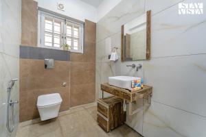 a bathroom with a toilet and a sink at StayVista at The Crystal Crest with Jacuzzi and BBQ in Dehradun +20 photos