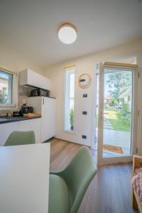 Una cocina y una sala de estar con mesa y sillas. en Green Apartments & Parking,Vimercate, en Vimercate