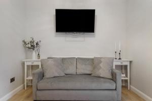 a living room with a couch and a flat screen tv at Milton Keynes 3BR,Spacious Home, Sleeps 5, Families Stays, Free Parking in Milton Keynes