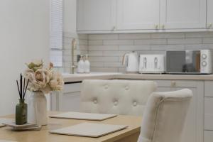 una cucina con un tavolo con un vaso di fiori di Milton Keynes 3BR,Modern Home, Sleeps 5, Families Stays, Free Parking a Milton Keynes