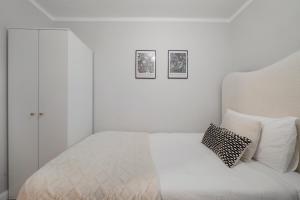 a bedroom with a white bed with two pictures on the wall at Milton Keynes 3BR,Stylish Home, Sleeps 5, Families Stays, Free Parking in Milton Keynes