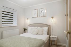 een witte slaapkamer met een bed en een raam bij Milton Keynes 3BR,Elegant Home, Sleeps 5, Families Stays, Free Parking in Milton Keynes