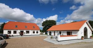 een groot wit gebouw met een oranje dak bij Sellebjerg Apartment in Bindslev