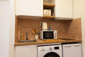 een keuken met een spoelbak en een magnetron bij DA-3-TURENNE-BM near Place des Vosges in Parijs