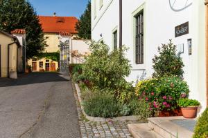 an alley with flowers and plants next to a white building at Adalbert Ecohotel in Prague