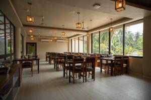 ein Restaurant mit Holztischen und -stühlen und Fenstern in der Unterkunft The Coral Bentley Hotels in Havelock Island + 10 Fotos
