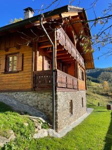 uma casa de madeira com uma varanda ao lado em Preisöxlhütte in Sankt Veit em Schwarzenbach