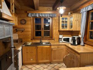 uma cozinha com armários de madeira e um lavatório numa cabina em Preisöxlhütte in Sankt Veit em Schwarzenbach mais 11 fotografias