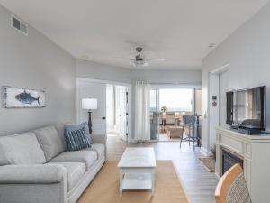 a living room with a couch and a tv at Ocean Pearl in Tybee Island