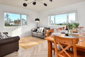 a living room with a table and a couch at Maes Coch in Abersoch