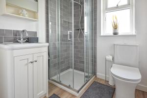 a bathroom with a shower and a toilet and a sink at Maes Coch in Abersoch +21 photos