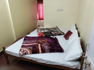 a bed with blankets and pillows on top of it at ooty hill stay in Ooty