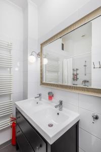 Un baño blanco con lavabo y espejo. en Central Budapest Apartment in Historical Building With Free Private Parking, en Budapest 37 fotos más