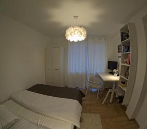 a bedroom with a bed and a desk and a chandelier at Apartament Rutkiewicz in Łańcut