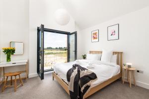 ein Schlafzimmer mit Bett, Schreibtisch und Fenster in der Unterkunft Brightside SV35 Silverlake Dorset in Warmwell