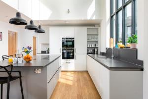 eine Küche mit weißen Schränken und schwarzen Arbeitsplatten in der Unterkunft Brightside SV35 Silverlake Dorset in Warmwell